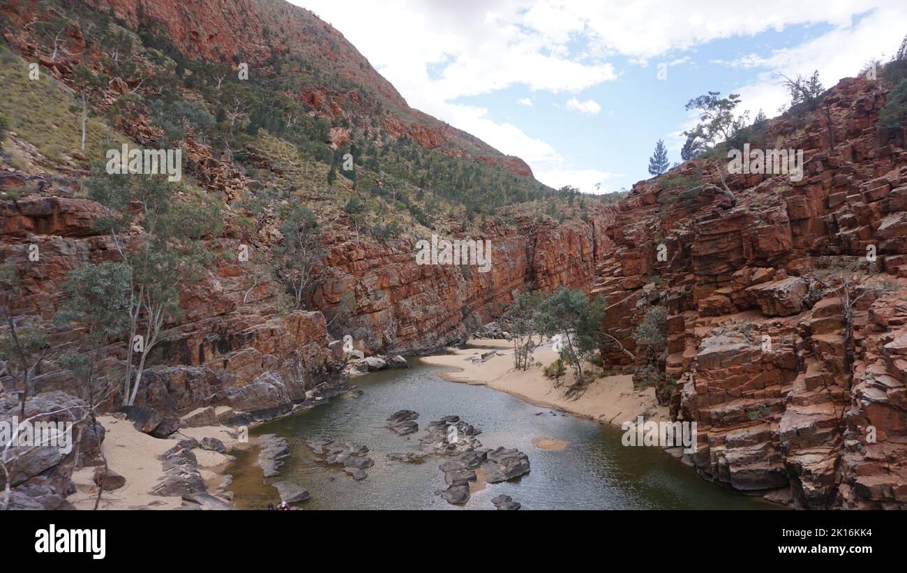 Splendida vista sulla gola rossa e l'acqua di sorgente dalla gola di Ormiston nella catena montuosa West Macdonnell nel Red Centre, Australia. Foto Stock