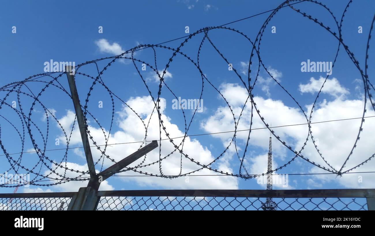 Vista diurna della recinzione in filo spinato. Chiudi Foto Stock