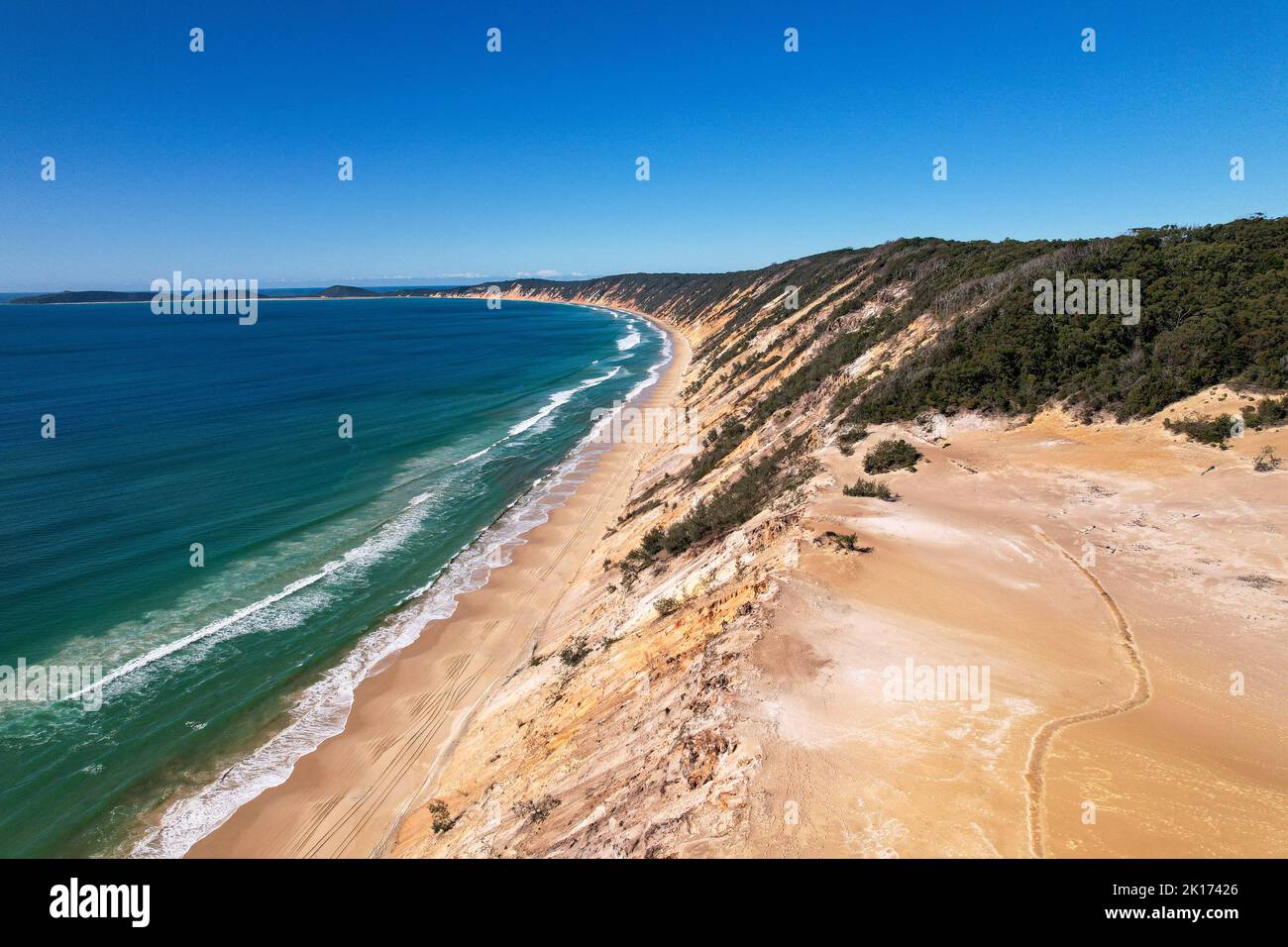 La vista dei droni di Rainbow Beach e Carlo Sand soffia da un alto punto panoramico nel Queensland, Australia. Si tratta di una lunga spiaggia circondata da scogliere. Foto Stock