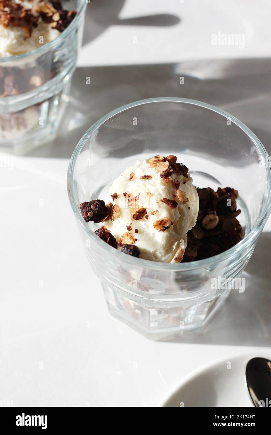 Dessert fatto in casa di granola con gelato alla vaniglia in bicchieri. Foto Stock
