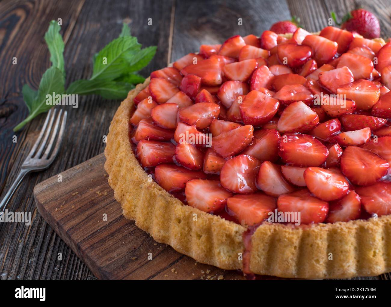 Crostata fatta in casa con fragole isolate su sfondo di legno Foto Stock