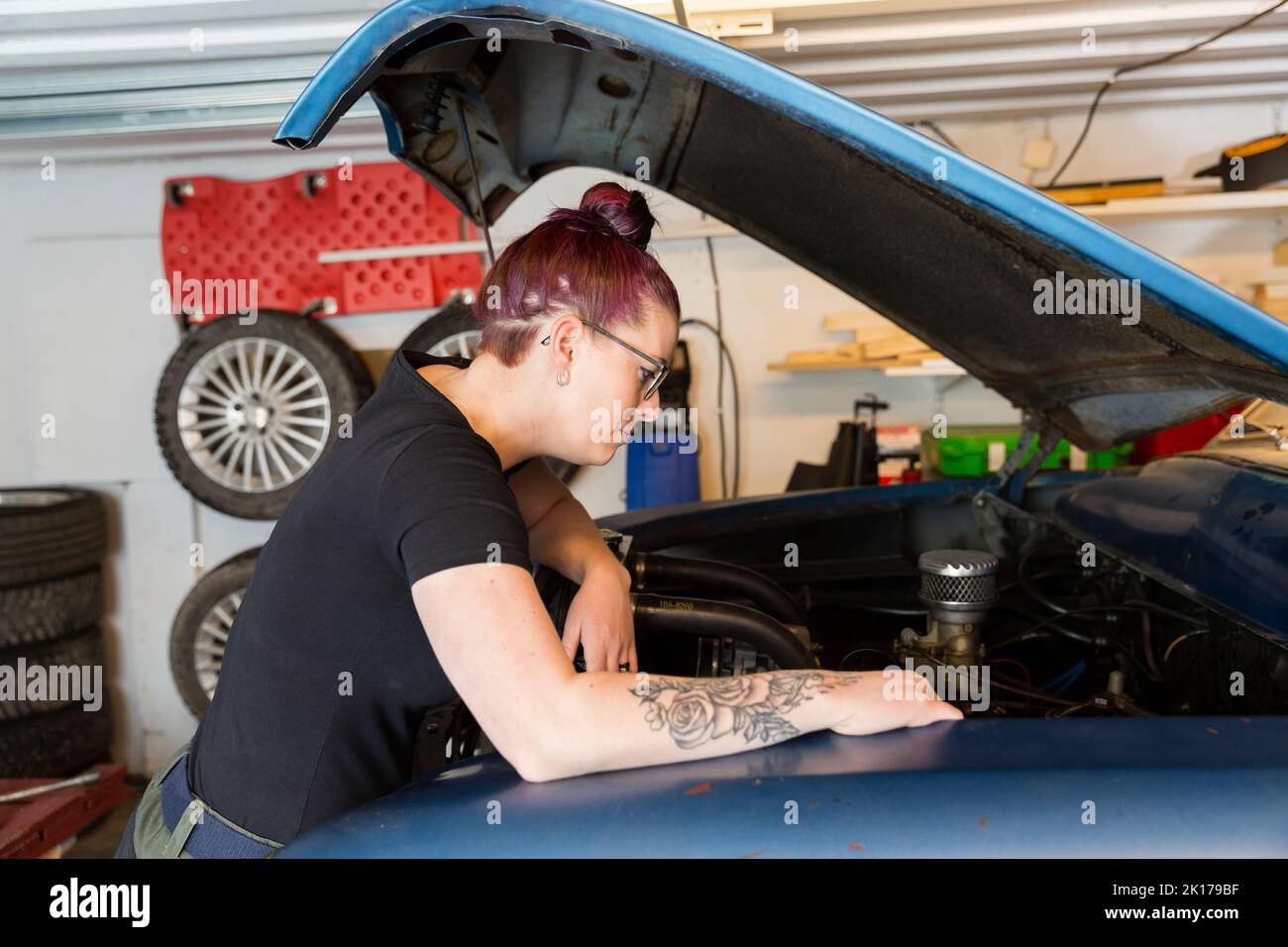 Donna riparazione auto d'epoca Foto Stock