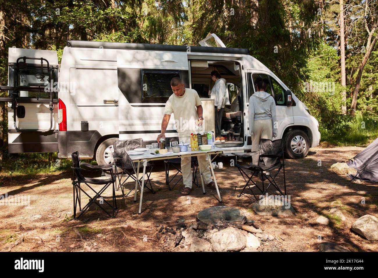 Persone che preparano il pasto nel campo Foto Stock