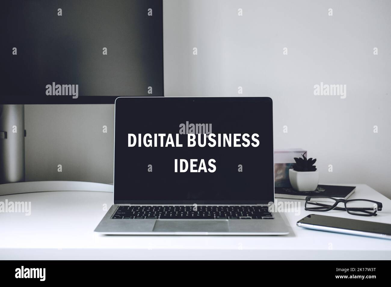 Idee per il business digitale. Commercio in linea. Spazio di lavoro moderno con testo idee digitali aziendali su schermo laptop, telefono cellulare, matita, su tavolo di lavoro bianco Foto Stock