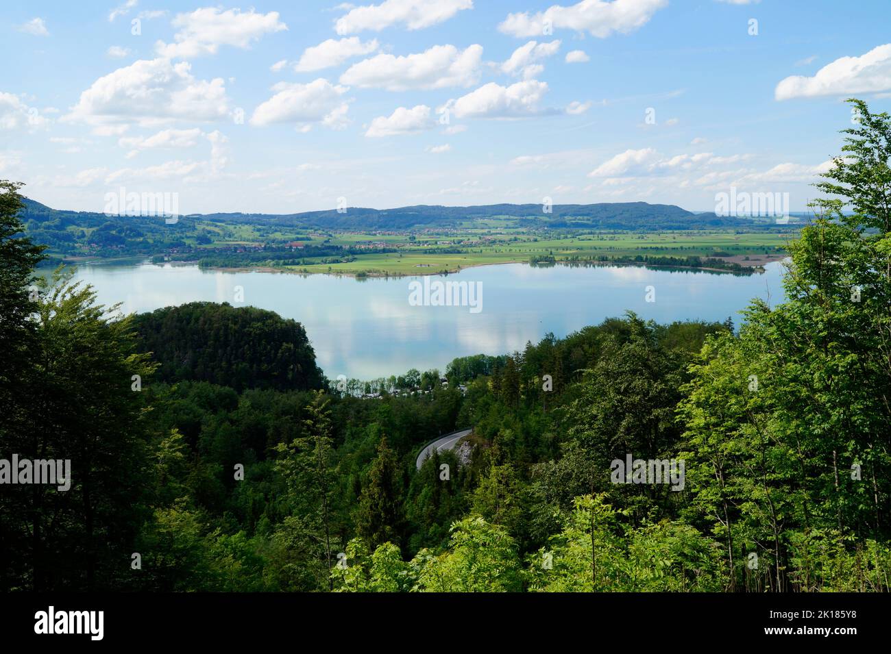 lago di Kochel o Kochelsee nelle panoramiche Alpi bavaresi circondato da lussureggianti alberi verdi in una giornata di sole a maggio (Baviera, Germania) Foto Stock