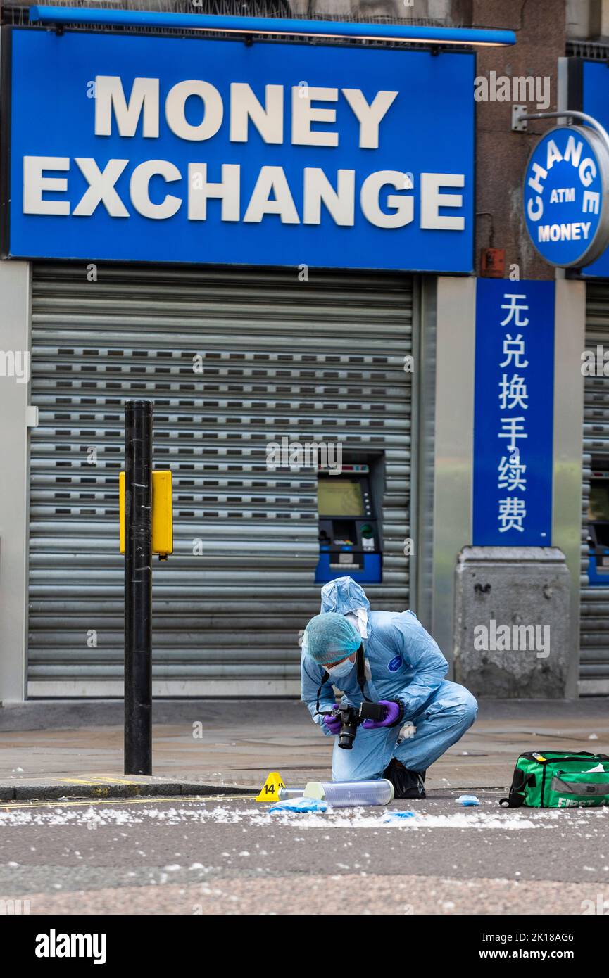 Londra, Regno Unito. 16 settembre 2022. Un ufficiale di medicina legale ispeziona le prove in una scena criminale a Coventry Street, vicino a Leicester Square e Chinatown. E' stato riferito che due poliziotti sono stati pugnalati e si trovano in ospedale. Un uomo dei suoi 20s anni è stato arrestato per sospetto di grave danno corporeo e per aver assalito un operaio di emergenza in un incidente che si è verificato alle 6am di questa mattina. Credit: Stephen Chung / Alamy Live News Foto Stock
