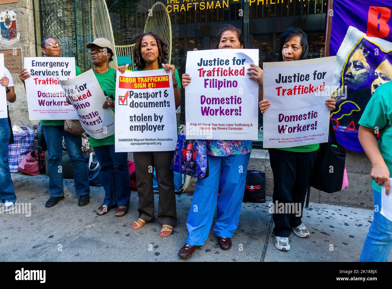 New York, New York, Stati Uniti, gruppo di donne immigrate che manifestano contro la tratta di esseri umani di lavoratori domestici filippini, Maids, che tengono cartelli di protesta in strada, discriminano noi, donne con segni di democrazia Foto Stock