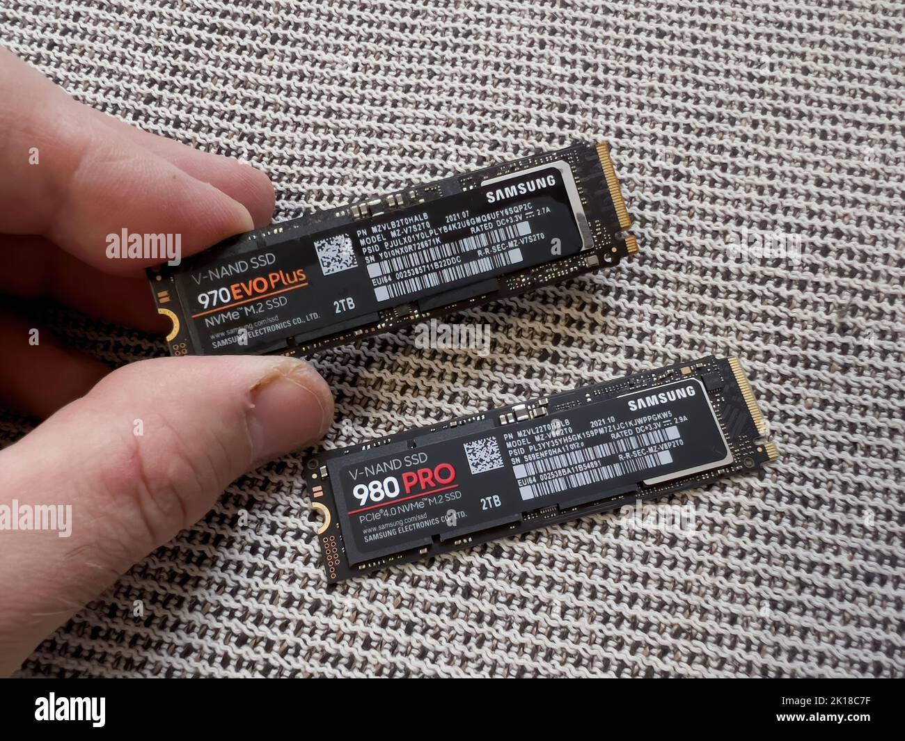 Parigi, Francia - 8 aprile 2022: Mano POV maschio che confronta il nuovo Samsung 980 Pro NVME unità disco rigido ssd per il personal computer o mac aggiornamento Apple con 970 Evo Plus Foto Stock