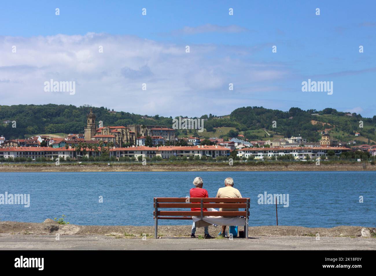 Una coppia anziana guarda Hondarribia (Spagna) attraverso il fiume Bidasoa da Hendaye, Paesi Baschi francesi, Francia Foto Stock