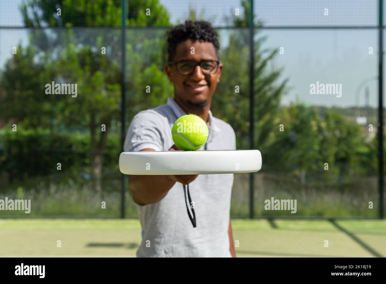 Giocatore di tennis nero palla di bilanciamento sulla racchetta Foto Stock