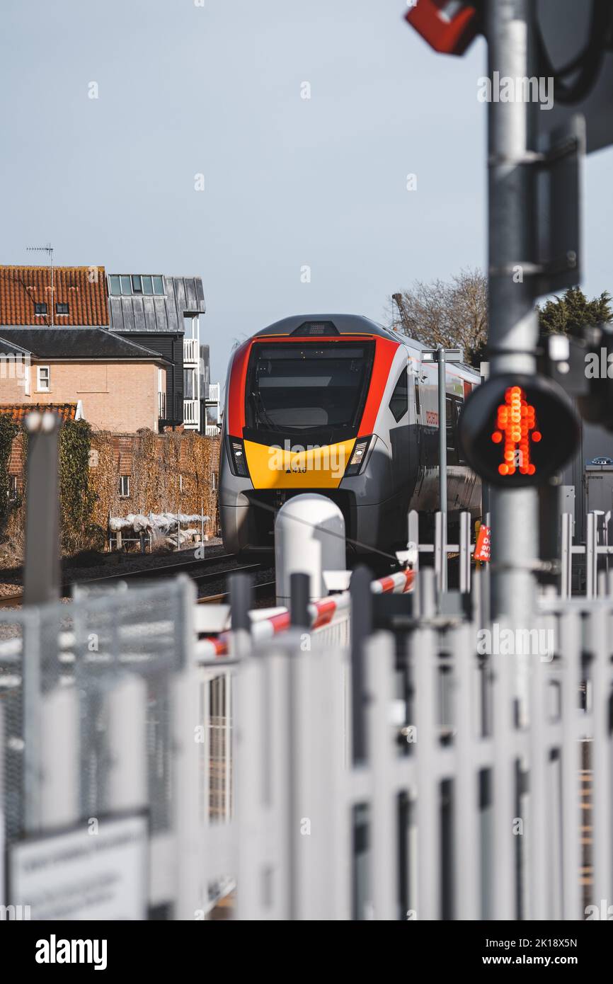 Un treno britannico che si tira su ad un passaggio di livello Foto Stock
