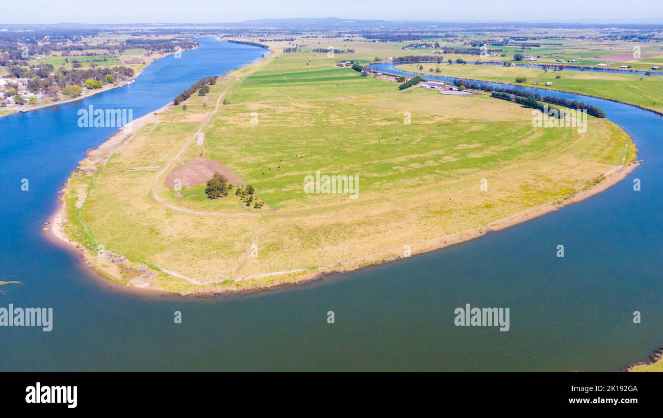 Una vista aerea della fattoria circondata da un bel fiume e lussureggiante erba verde vicino a Newcastle Foto Stock