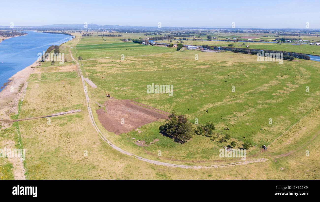 Una vista aerea della fattoria circondata da un bel fiume e lussureggiante erba verde vicino a Newcastle Foto Stock