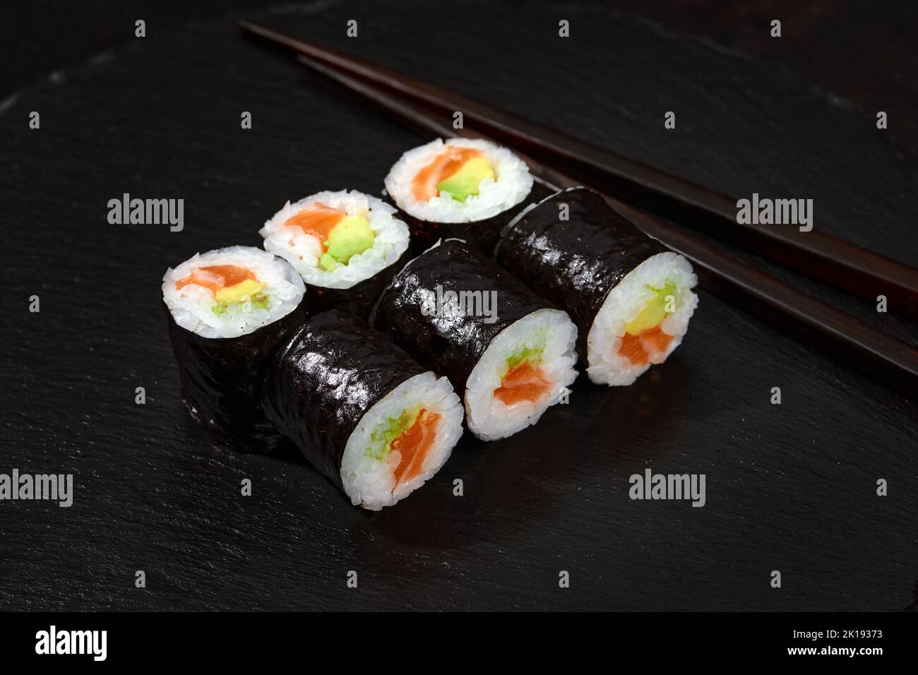 Set di panini di sushi di tonno e avokado su sfondo nero Foto Stock