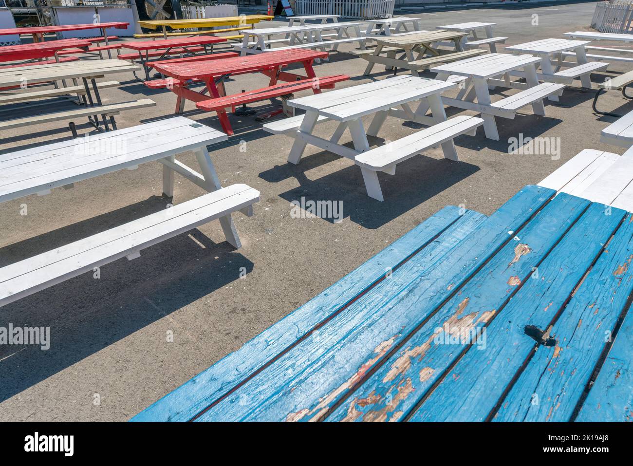 San Antonio, Texas - tavolo da pranzo in legno dipinto di blu, rosso, giallo, bianco con sedie. Tavoli in legno con posti a sedere su un terreno in cemento. Foto Stock
