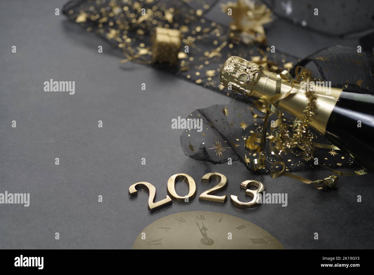 Concetto di Capodanno, con luce brillante e bottiglia di champagne, sfondo bokeh dorato Foto Stock