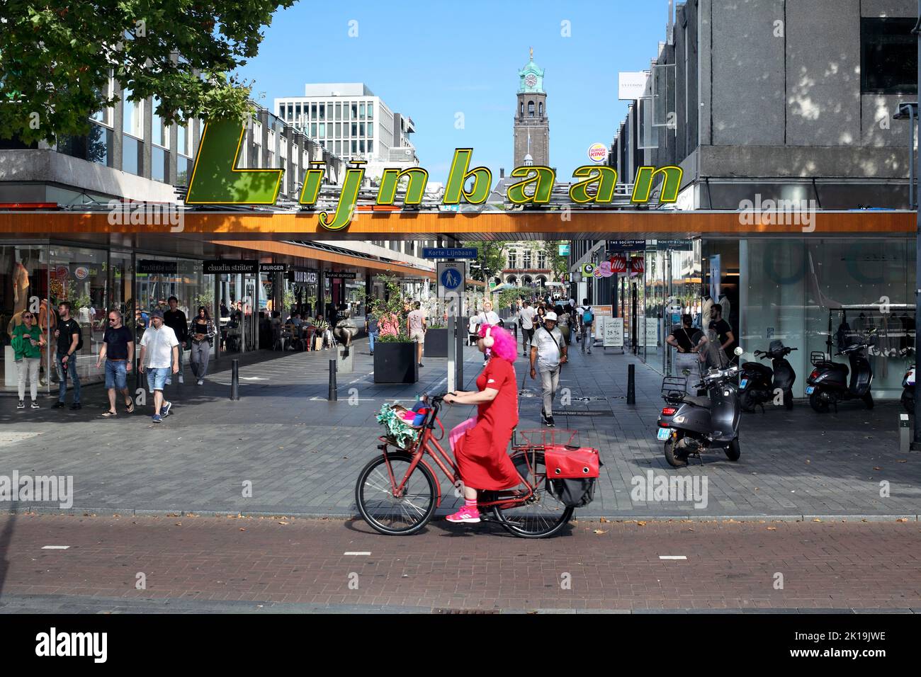 Pista ciclabile accanto alla zona commerciale di Lijnbaan a Rotterdam, Paesi Bassi. (Guardando verso la torre dell'orologio del Municipio di Rotterdam). Foto Stock