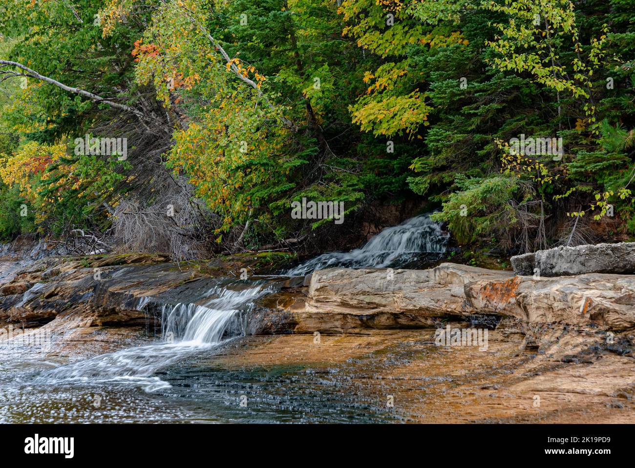 Le cascate del minatore sono una piccola cascata che si affaccia fuori dalla foresta sul lago superiore, su sporgenze di arenaria, Rocks National Lakeshore, Alger Count Foto Stock
