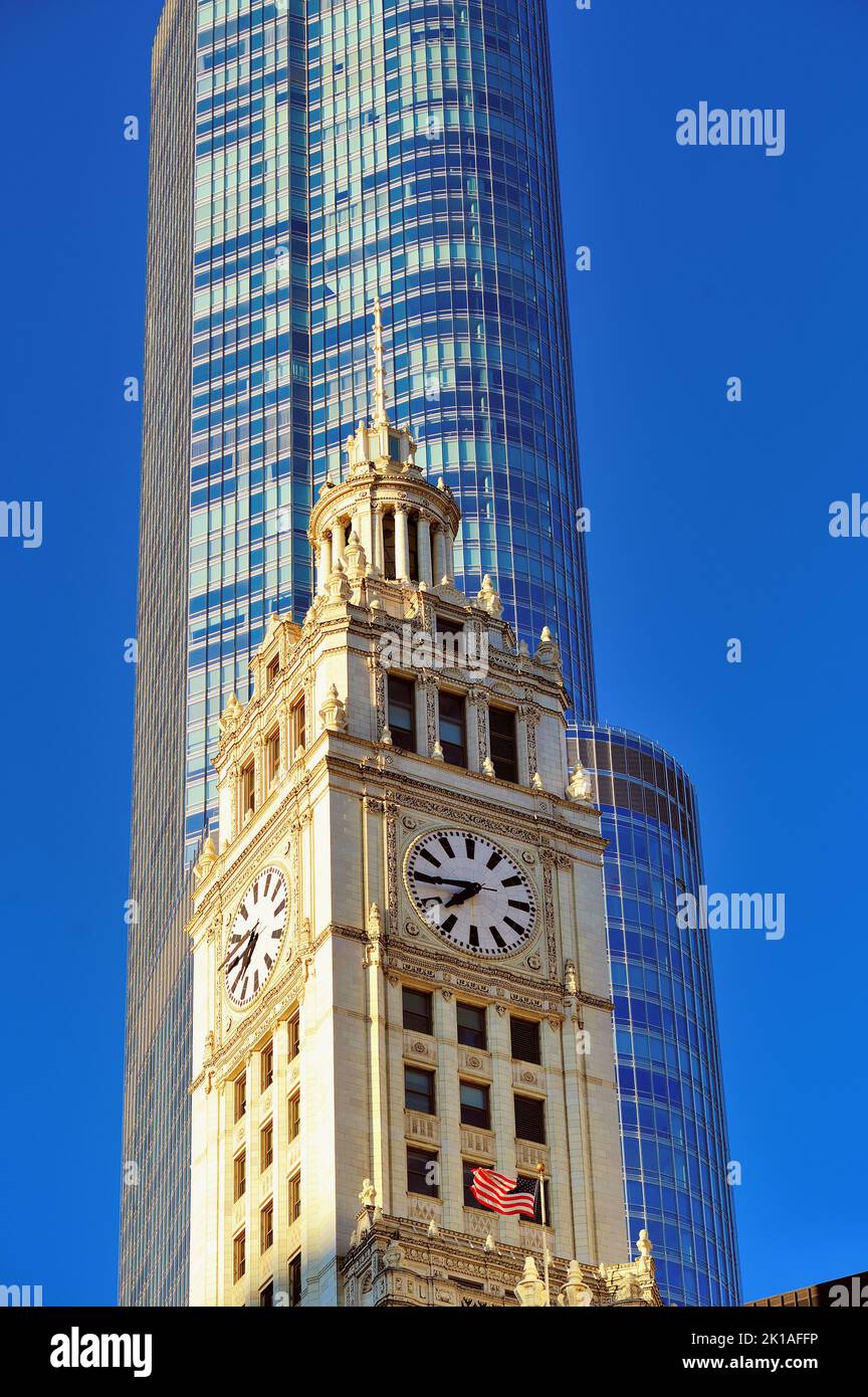 Chicago, Illinois, Stati Uniti. Il Wrigley Building e la bandiera americana sono in contrasto con la modernissima Trump Tower sullo sfondo. Foto Stock