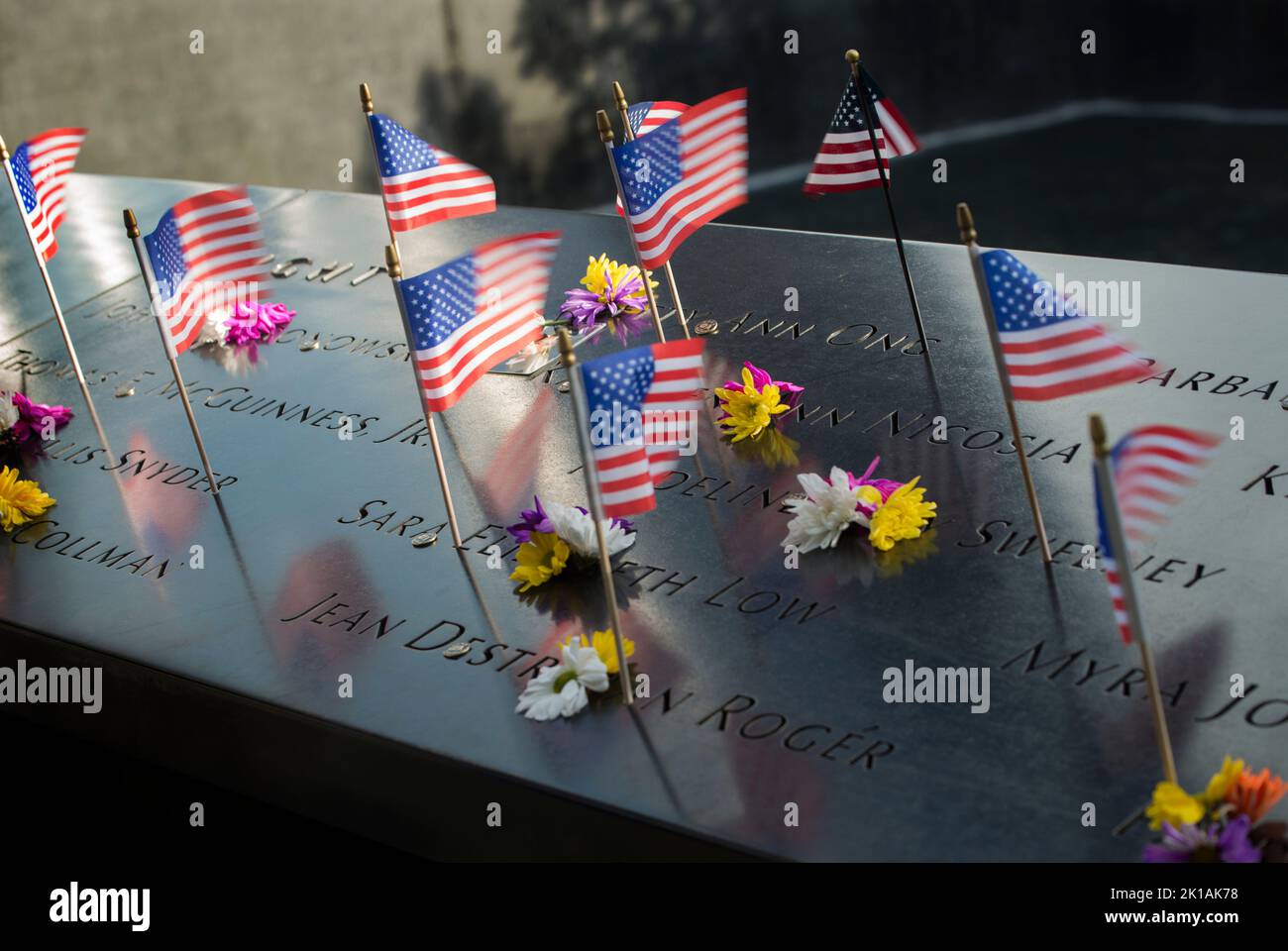 World Trade Center, New York, New York, 10 settembre 2022. Un giorno prima del 21st° anniversario degli attacchi terroristici suicidi contro il World Trade Center (WTC) bandiere americane poste ai nomi incisi delle vittime del 9/11attacks al North Pool 9/11 Memorial. Foto Stock