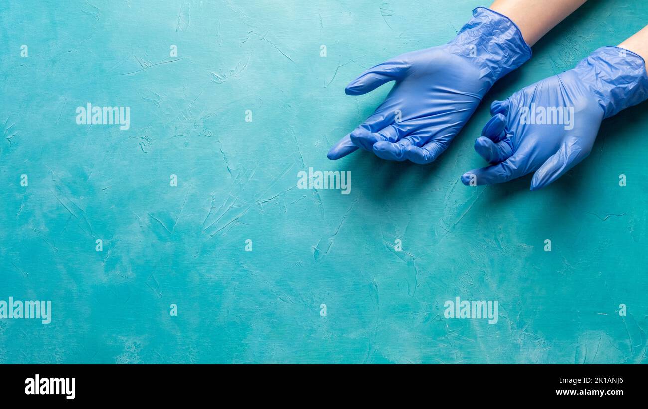 Restrizione pandemica. Assistenza medica. Mani di infermiera stanche in guanti di medicina su copia blu spazio. Misure COVID-19. Prevenzione della quarantena. Protezione igienica Foto Stock