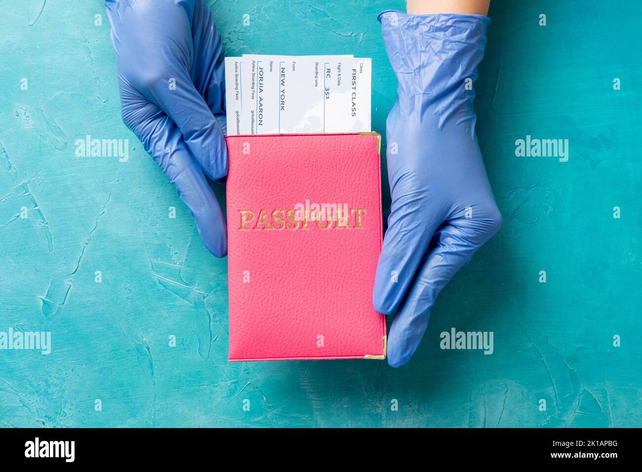 Limitazione di viaggio. Controllo dei passaporti. Guanti per uso medico con documento d'identità con biglietti in blu. Prevenzione delle pandemie. Protezione igienica Foto Stock