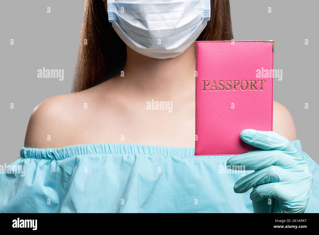 Prevenzione COVID-19. Controllo dei passaporti. Donna in maschera di tenuta con ID straniero. Prevenzione del coronavirus. Quarantena cura sicura Foto Stock
