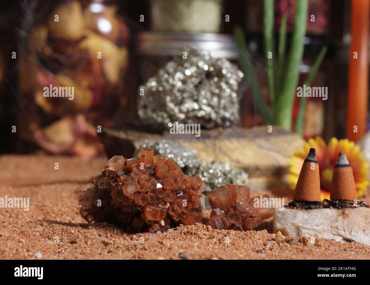 Cristallo di aragonite con coni di incenso sulla Tabella di meditazione di sabbia rossa australiana Foto Stock