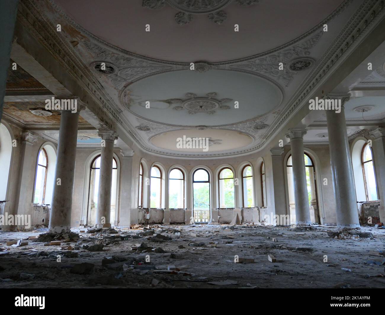 L'interno di una Sala da ballo abbandonata di un hotel con finestre ad arco a Tskaltubo, Georgia Foto Stock