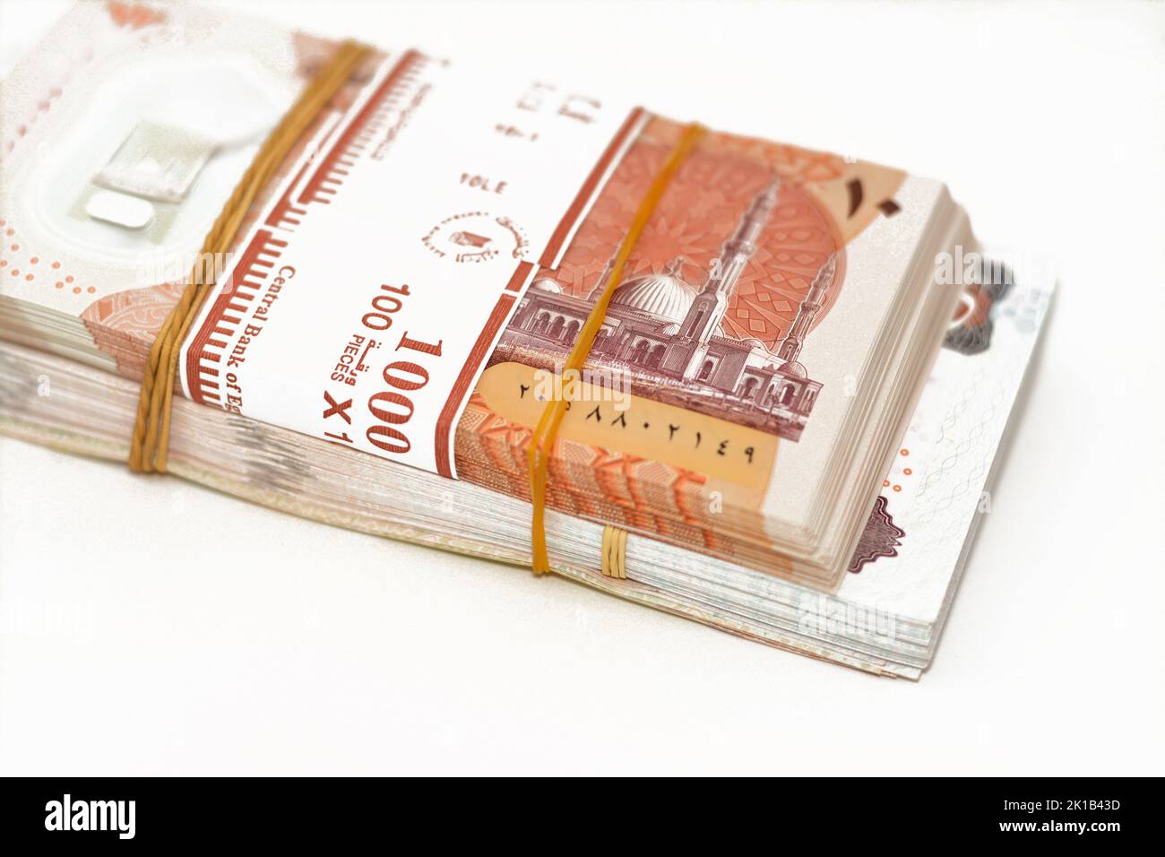 Fuoco selettivo di pila di nuove banconote egiziane valuta di diversi valori con fasce di gomma isolate su sfondo bianco, pila di nuovo poli Foto Stock