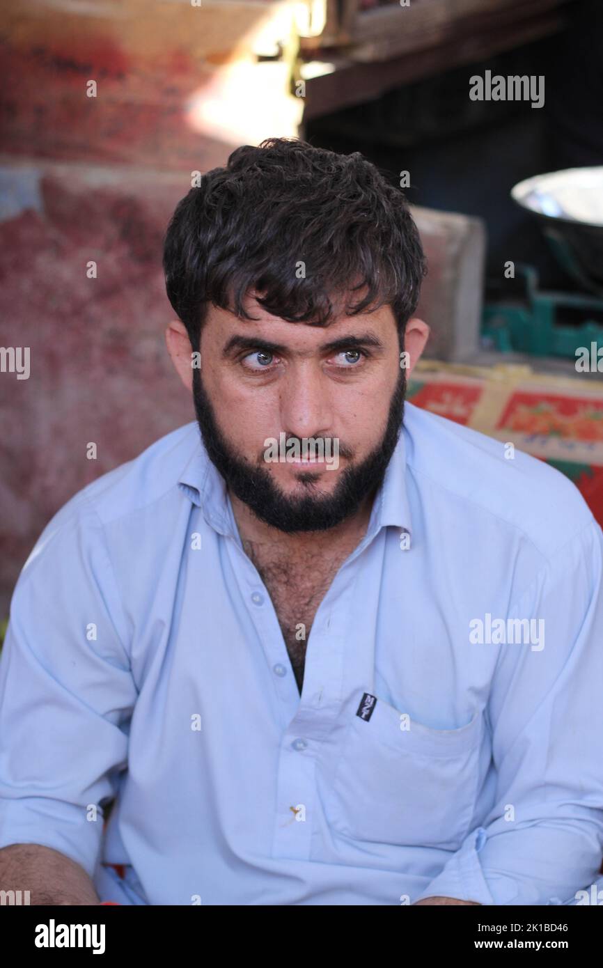 Un fuoco poco profondo di un maschio pakistano con una barba che guarda arrabbiato Foto Stock