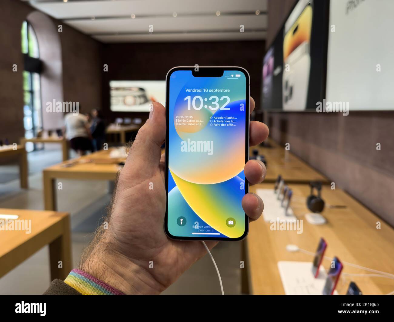 Parigi, Francia - 16 settembre 2022: POV mano maschio tenere nuovo color viola Apple computer iPhone 14 durante il giorno di lancio con la nuova fotocamera doppia potente auto rilevamento urti e satellite SOS Foto Stock