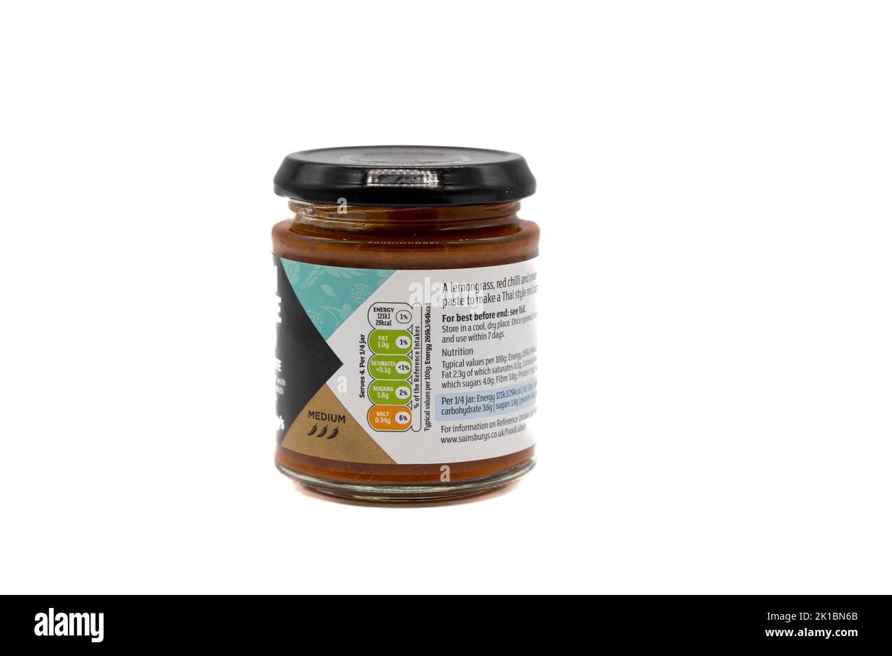 Irvine, Scozia, Regno Unito - 20 agosto 2022: Pasta di curry rossa in vetro riciclabile con marchio Sainsbury, in stile thailandese, con la classificazione media dei simboli e. Foto Stock