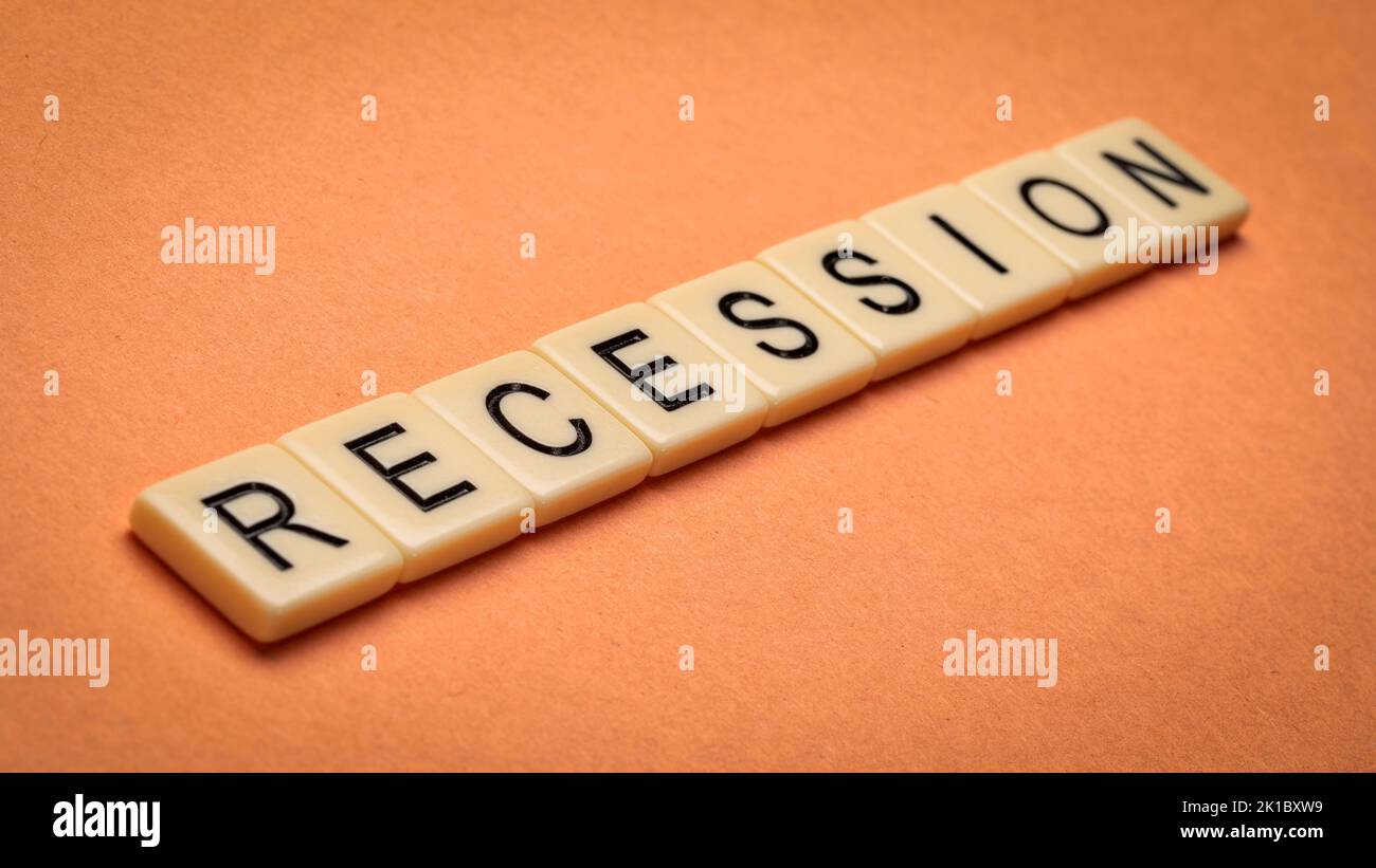 parola recessione in piastrelle di lettera avorio contro carta testurizzata fatta a mano, business e concetto di economia Foto Stock