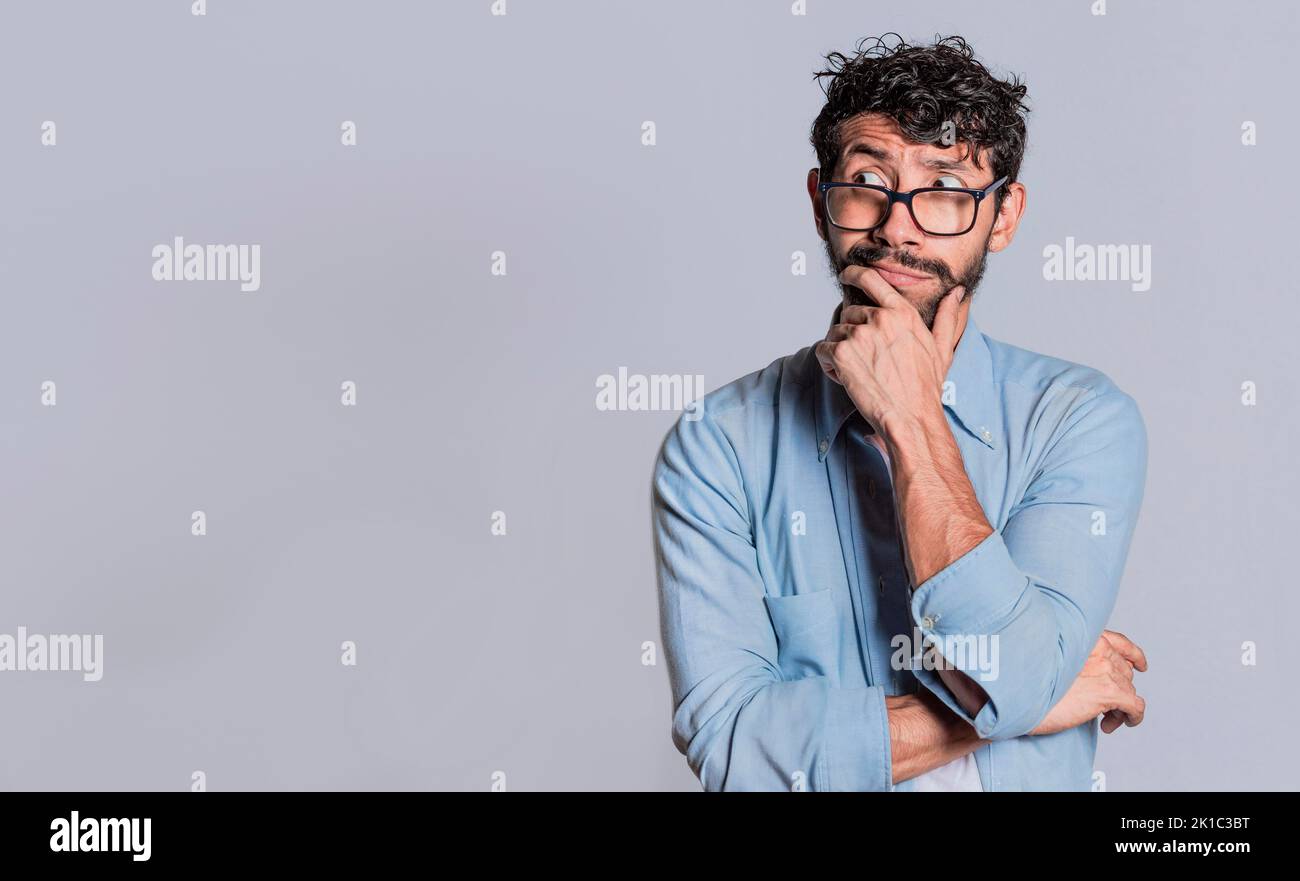 Bell'uomo che si chiede con la mano sul mento guardando da parte isolata, la persona che si chiede con la mano sul mento vedere spazio vuoto, concetto di persona premurosa Foto Stock