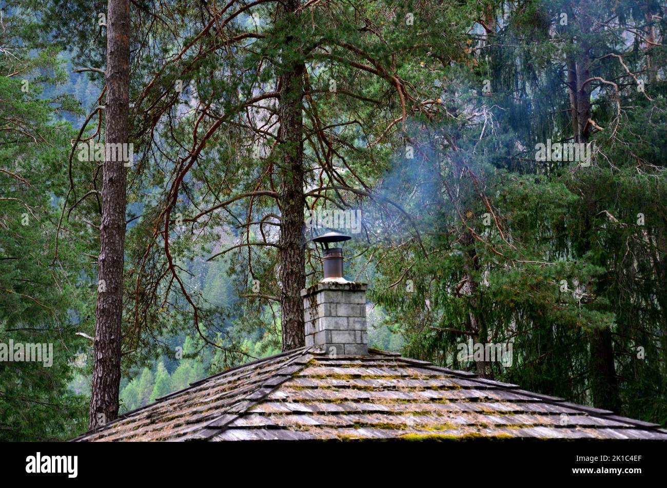 Il fumo esce dal camino sul tetto della struttura barbecue nell'area pic-nic della foresta di Anterselva Foto Stock