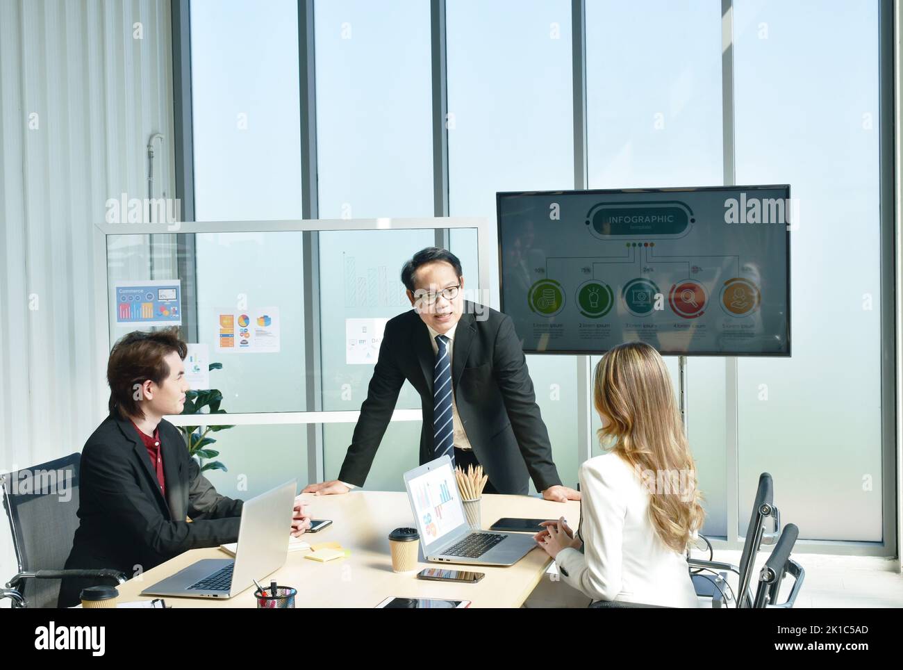 Uomo e donna d'affari asiatici che si incontrano e disusano il lavoro in sala ufficio Foto Stock