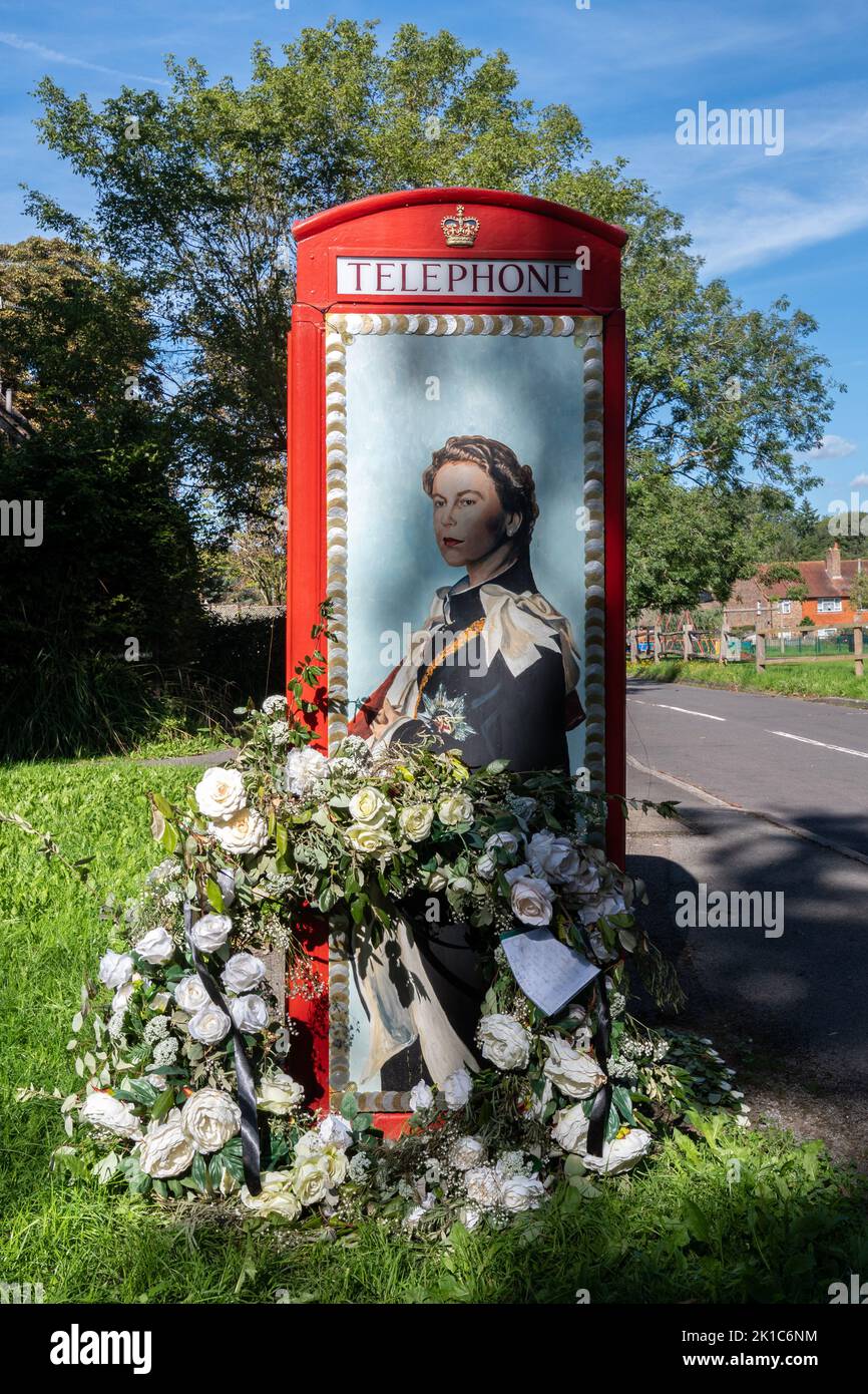 Scatola telefonica rossa decorata per onorare la regina Elisabetta II dopo la sua morte nel settembre 2022 nel villaggio Surrey di Compton, Inghilterra, Regno Unito Foto Stock