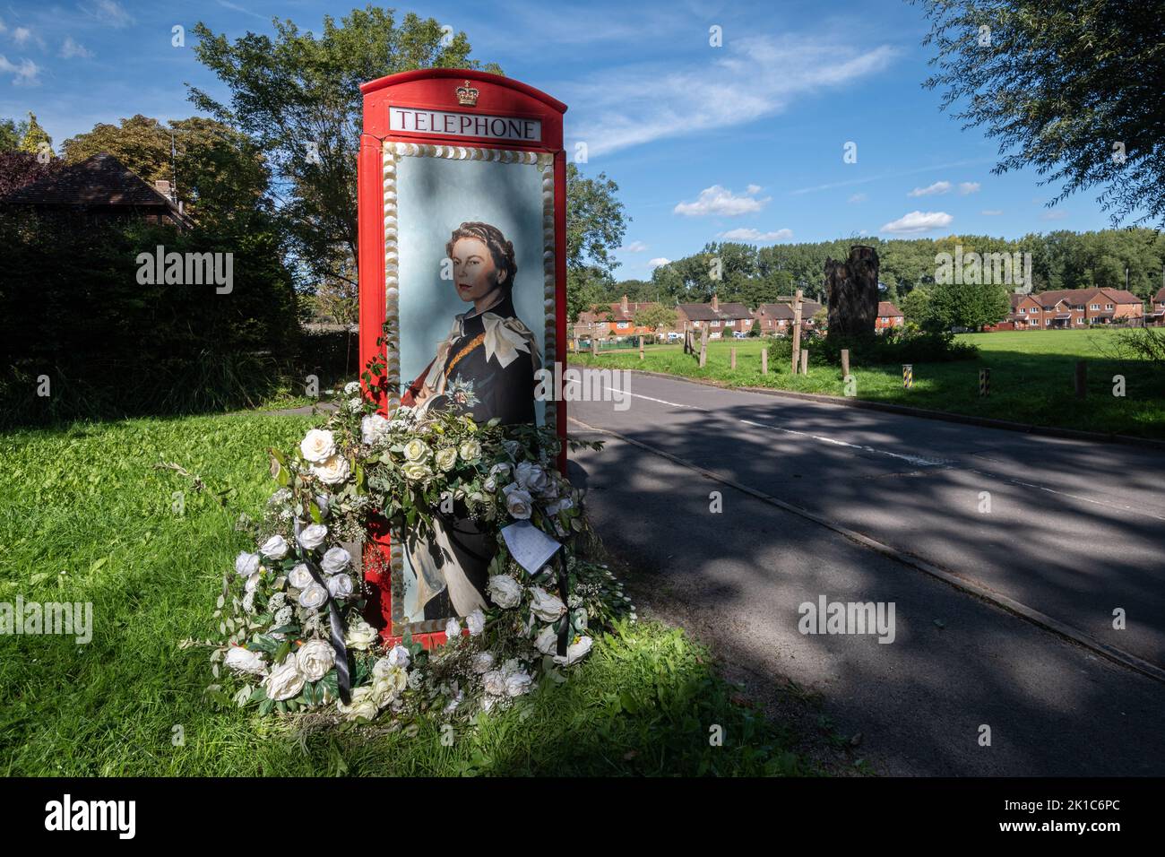 Scatola telefonica rossa decorata per onorare la regina Elisabetta II dopo la sua morte nel settembre 2022 nel villaggio Surrey di Compton, Inghilterra, Regno Unito Foto Stock