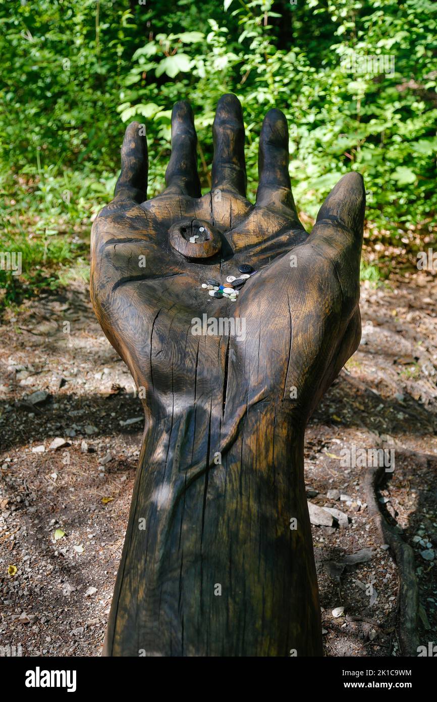 Pfullinger Sagenweg, mano con un Remmsele, bottoni per pantaloni rotondi, sacrificio per l'Urschel, figure in legno di Billy Troege, lavorazione artistica del legno, arte Foto Stock