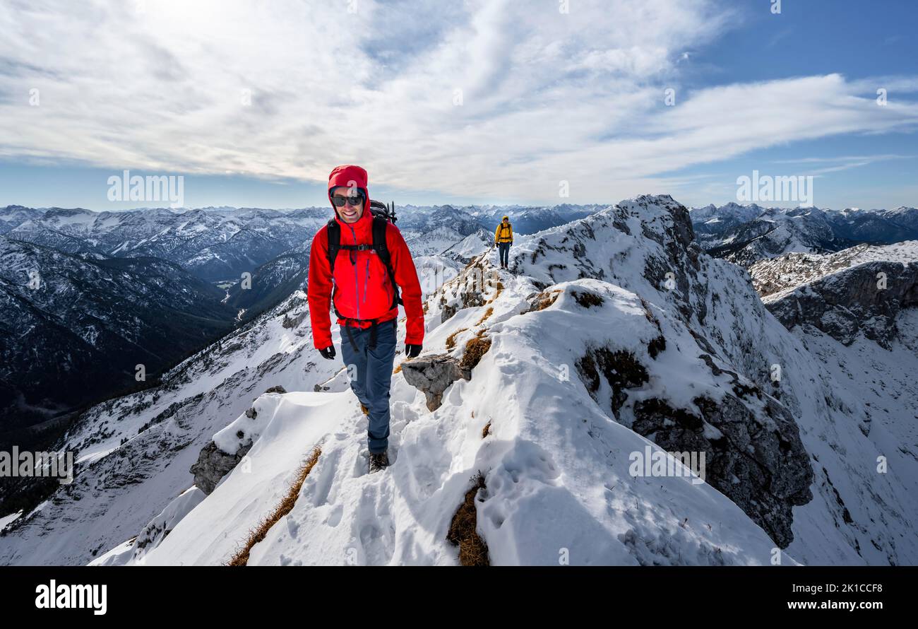 Due alpinisti su una stretta cresta rocciosa nevosa, dietro il crow di picco, vista del panorama montano, escursioni a Ammergauer Hochplatte, in autunno, Ammergau Foto Stock