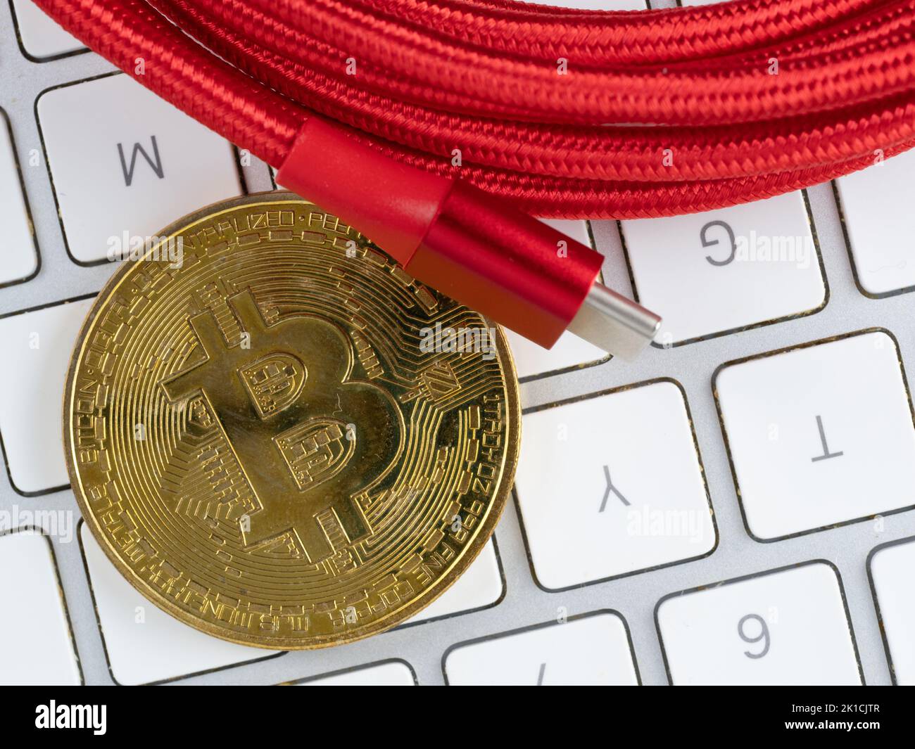 Cavo rosso USB C bitcoin oro e tastiera per computer Foto Stock