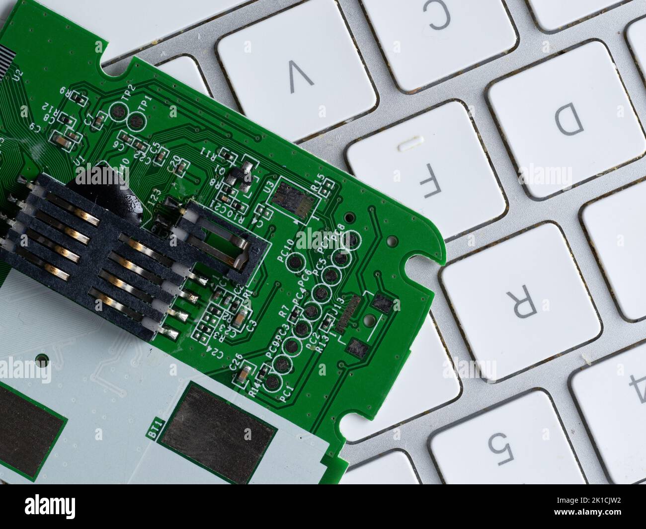 scheda a circuito stampato con condensatori resistori su una tastiera per computer Foto Stock