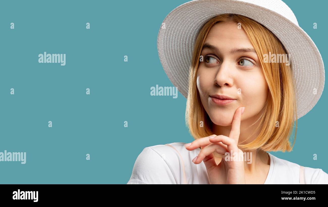 Viaggio di vacanza. Offerta di viaggio. Donna Coquettish in cappello zingaro bianco cercando copia spazio isolato su blu. Tour estivo. Offerta migliore. Sfondo pubblicitario Foto Stock