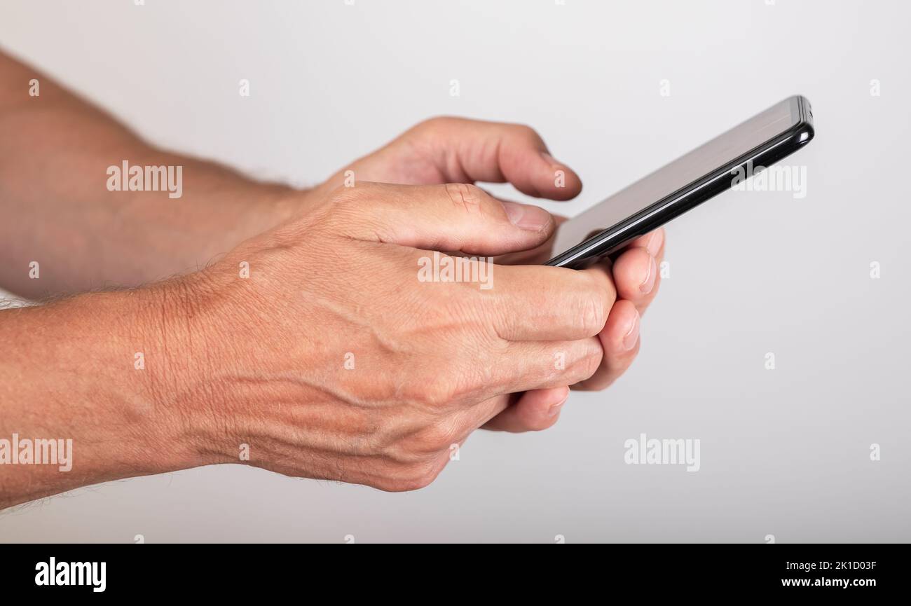 Uomo mani primo piano messaggio di testo al telefono. Uomo che usa Messenger per chattare o navigare in Internet. Telefono per la comunicazione online. ph di alta qualità Foto Stock