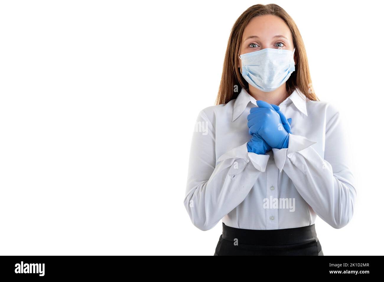 Prevenzione di Covid-19. Donna ispirata. Back Office. Misure di quarantena. Giovane donna in maschera di protezione guanti tenendo le mani speranza guardando fotocamera isola Foto Stock