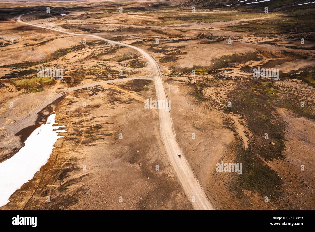 Vista aerea del ciclista cavalcando su strada sterrata tra la natura selvaggia vulcanica nelle Highlands islandesi in estate in Islanda Foto Stock