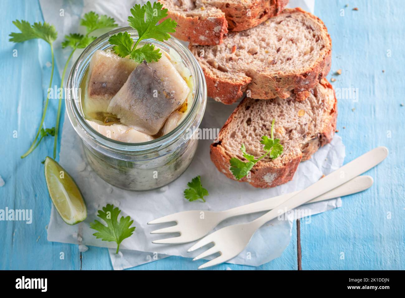 Aringhe marinate fresche e deliziose come fonte di grassi omega. Pesce in vaso servito con pane. Foto Stock