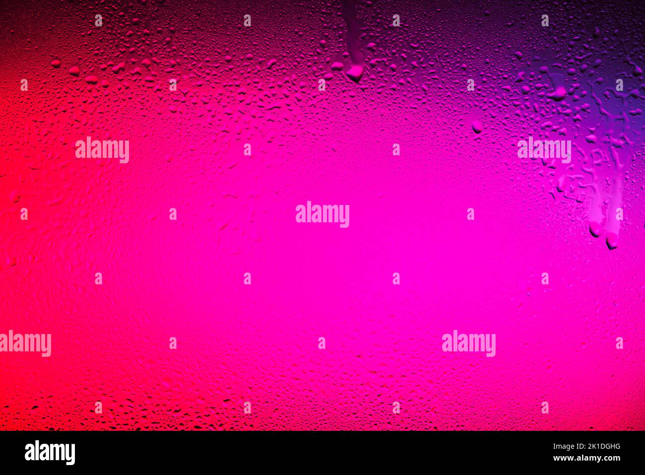 Texture creata in un bicchiere con gocce d'acqua su sfondo colorato. Foto Stock