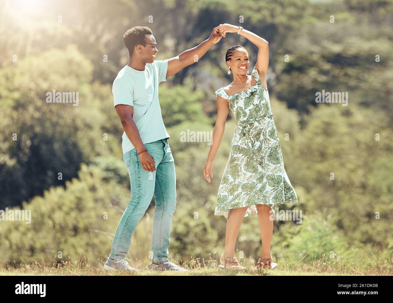 Amore, libertà e celebrazione da coppia ballando all'aperto, amando fuga romantica e legame. Felice uomo e donna neri che sono giocosi e dolci Foto Stock